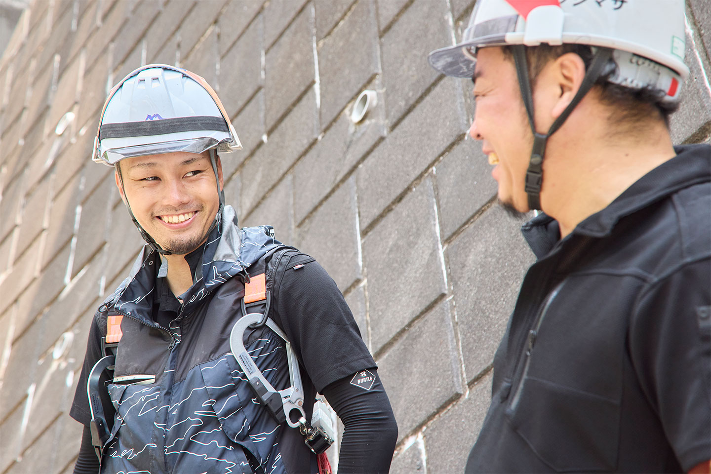 2人の作業員が笑顔で会話している様子